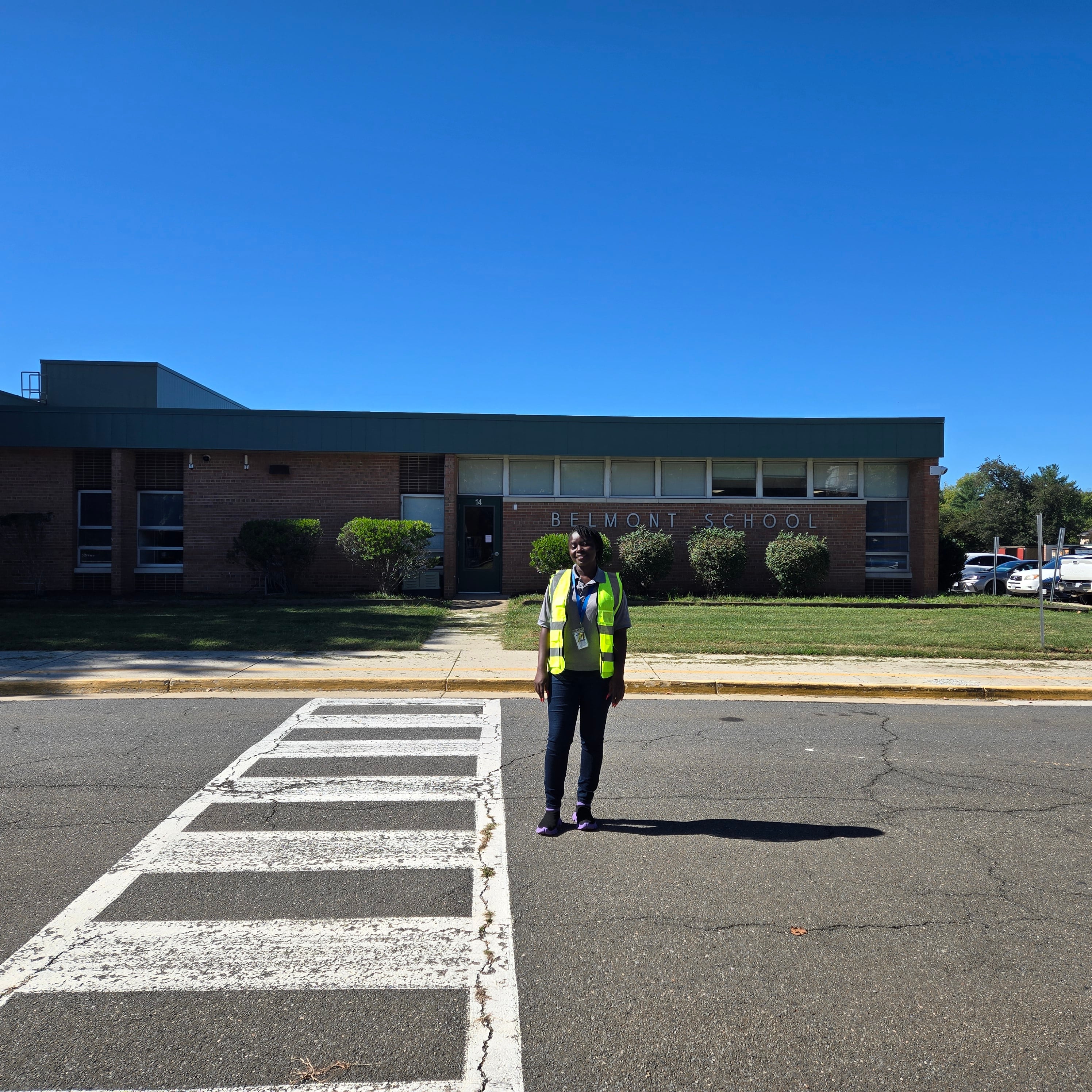 school security office in safety vest in front of elementary school